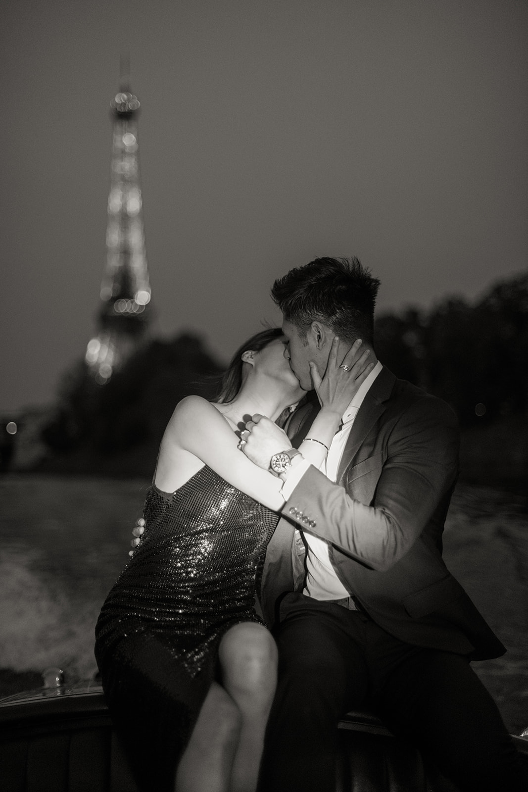 Couple kissing during a romantic Paris proposal photo session with the Eiffel Tower at night
